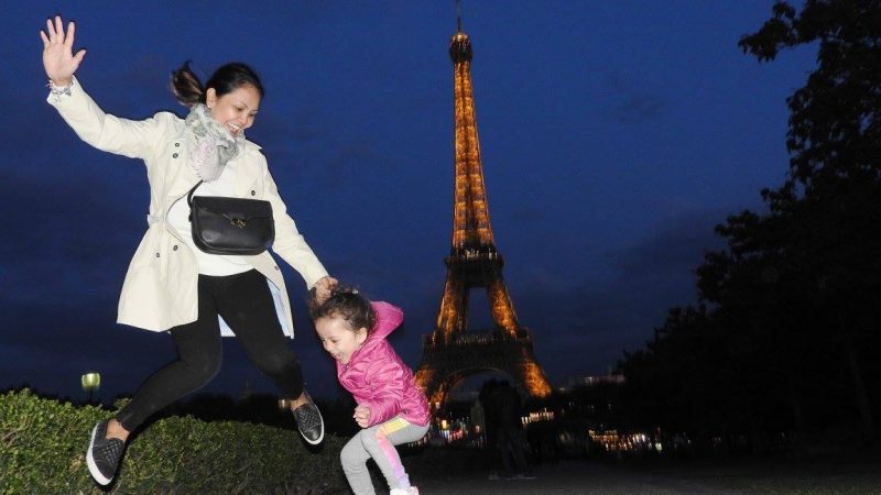 Lara and Mom at the Eiffel Tower by night. Lara is the world's youngest travel blogger.